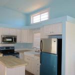 Platinum painted interior walls in blue with white beach-house style interior and stainless steel appliances