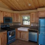 Platinum Cabin with hickory cabinets, stainless steel appliances, farm sink, and a pine ceiling